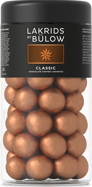 A jar of Candy: Lakrids by Bülow - Classic Caramel (295g), featuring licorice and caramel-infused chocolate-coated balls, comes with a black label detailing the product.