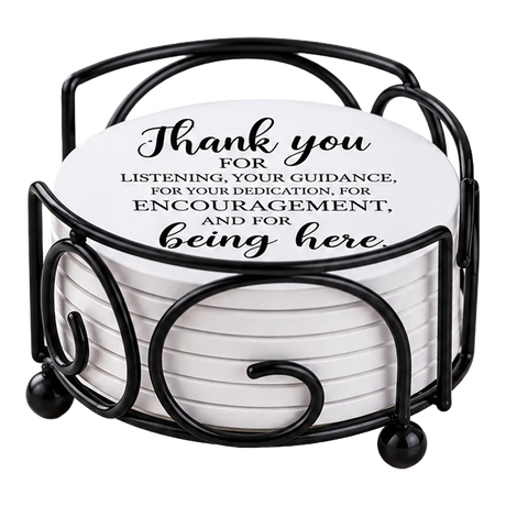 Round white drink coasters stacked in a black metal holder; the top coaster reads, “Thank you for listening, your guidance, and encouragement.”.