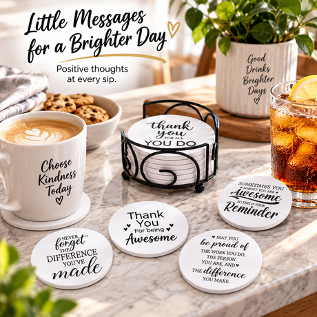 Coffee mugs and iced drinks on a wooden table in sunlight, with coasters displaying visible inspirational phrases.