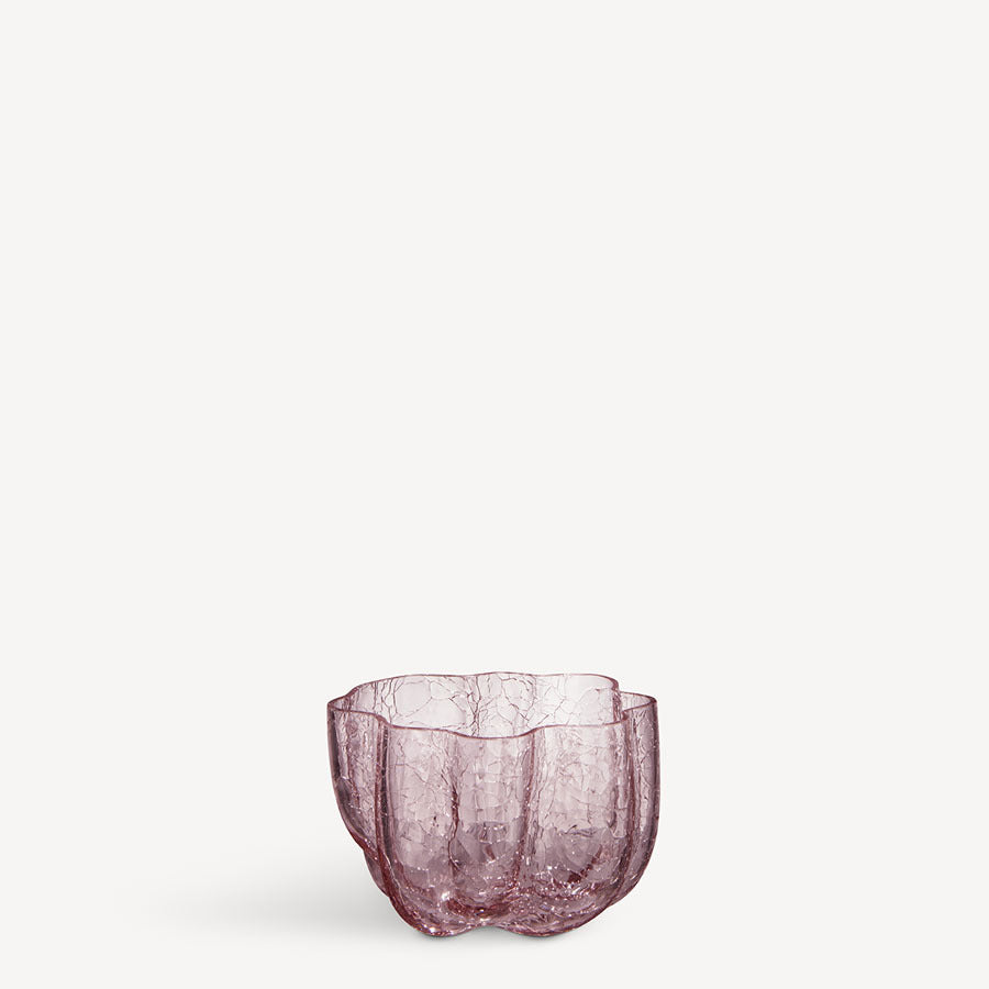 The KostaBoda: Crackle Bowl Votive Pink is a transparent purple glass vase designed by Åsa Jungnelius, featuring an irregular, organic shape and textured surface that resembles a crackle bowl against a plain white background.