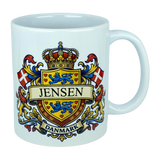 Elevate your drinkware with the Nordic Wholesale Mug: Denmark Coat of Arms Custom Name Ceramic Mug (11 oz Capacity)—a white ceramic heritage mug showcasing a vibrant Danish family crest with the Jensen name, blue lions, red Danish flags, a crowned shield, and "Danmark" below—ideal as a personalized Denmark mug.