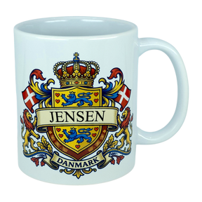 Elevate your drinkware with the Nordic Wholesale Mug: Denmark Coat of Arms Custom Name Ceramic Mug (11 oz Capacity)—a white ceramic heritage mug showcasing a vibrant Danish family crest with the Jensen name, blue lions, red Danish flags, a crowned shield, and "Danmark" below—ideal as a personalized Denmark mug.