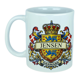 Enjoy your favorite beverages in the Mug: Denmark Coat of Arms Custom Name Ceramic Mug (11 oz Capacity) from Nordic Wholesale. This white ceramic mug showcases a vibrant Danish coat of arms design featuring lions, flags, a crown, and bold "Jensen" and "Danmark" lettering—perfectly blending tradition and style for any Danish heritage enthusiast.