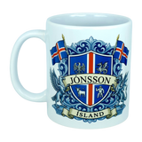 This Mug: Iceland Coat of Arms Custom Name Ceramic Mug (11 oz) by Nordic Wholesale features a white design adorned with a blue and red Icelandic crest, the surname Jónsson on a banner, national flags, mythical landvættir creatures, and "ÍSLAND" at the base—an eye-catching tribute to Icelandic heritage.