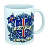Experience the unique heritage of Iceland with the Mug: Iceland Coat of Arms Custom Name Ceramic Mug (11 oz Capacity) by Nordic Wholesale—a white ceramic mug featuring a striking blue and red Icelandic crest labeled Jönsson Ísland, flanked by Icelandic flags and mythical creatures on a crisp white background, making it an ideal Landvættir-inspired gift for lovers of Icelandic tradition.