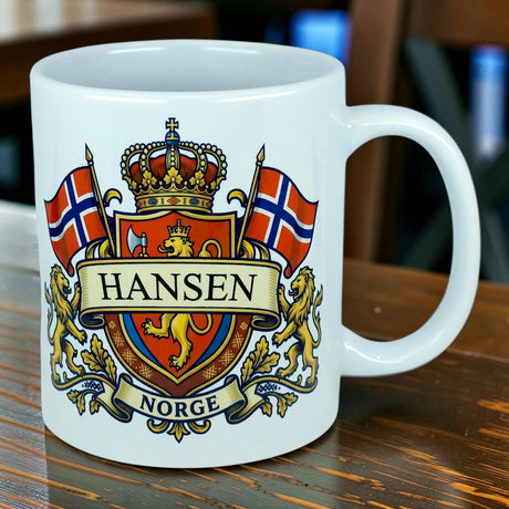 The Nordic Wholesale Mug: Norway Coat of Arms Custom Name Ceramic Mug (11 oz Capacity) features a vibrant crest with two lions, a crown, and twin Norwegian flags above the customizable text "Hansen" and "Norge," set elegantly on a wooden table. This personalized ceramic mug is an ideal Norway heritage gift for proud families seeking a unique keepsake.