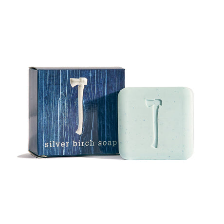 A light blue square vegan Silver Birch Soap 5.4 oz bar with an axe emblem is displayed next to its dark blue box labeled Silver Birch Soap.