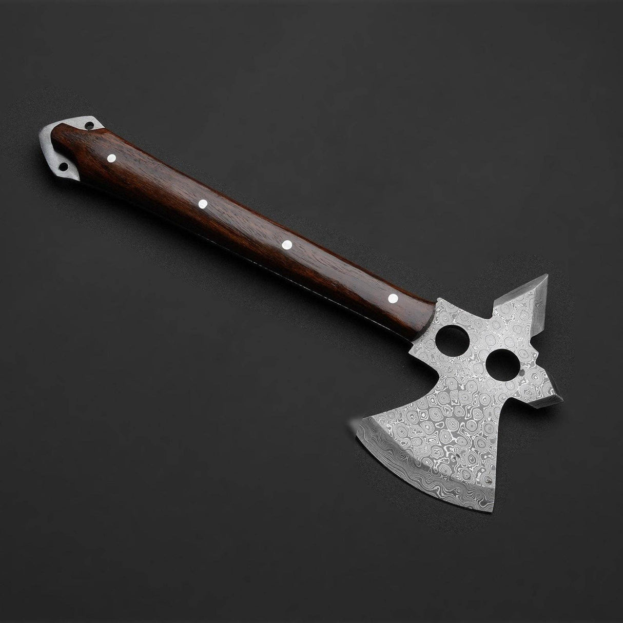 Patterned Damascus axe with a wooden handle, silver bolts, and two holes near the blade’s top, displayed on a solid black background.