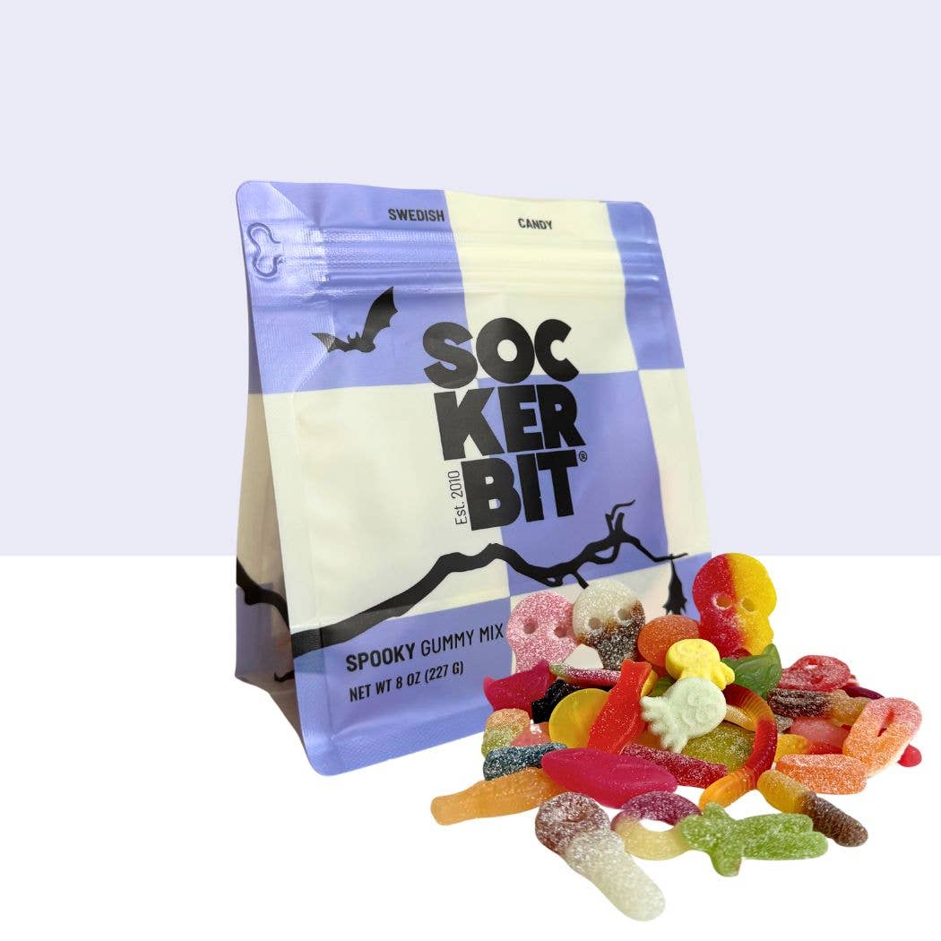 An 8 oz bag labeled “Candy: Spooky Swedish Gummy Mix” stands upright beside colorful Swedish gummies shaped like skulls, bats, and worms—ideal for Halloween candy fans.