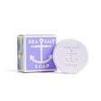 A round Sea Salt Lavender Swedish Dream Bar Soap, triple milled and natural, features an anchor emboss and sits beside its purple and white box. This 4 oz bar blends sea salt benefits with soothing lavender for gentle skincare.