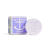 A round Sea Salt Lavender Swedish Dream Bar Soap, triple milled and natural, features an anchor emboss and sits beside its purple and white box. This 4 oz bar blends sea salt benefits with soothing lavender for gentle skincare.