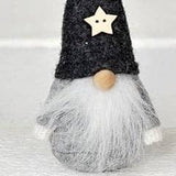 Scandinavian gnome figurine with a grey wool felt hat, a white star ornament, and a long white beard.