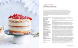 Saffron layer cake with white frosting and red berries on a cake stand, visible layers, Scandinavian style; recipe page placed next to the cake.