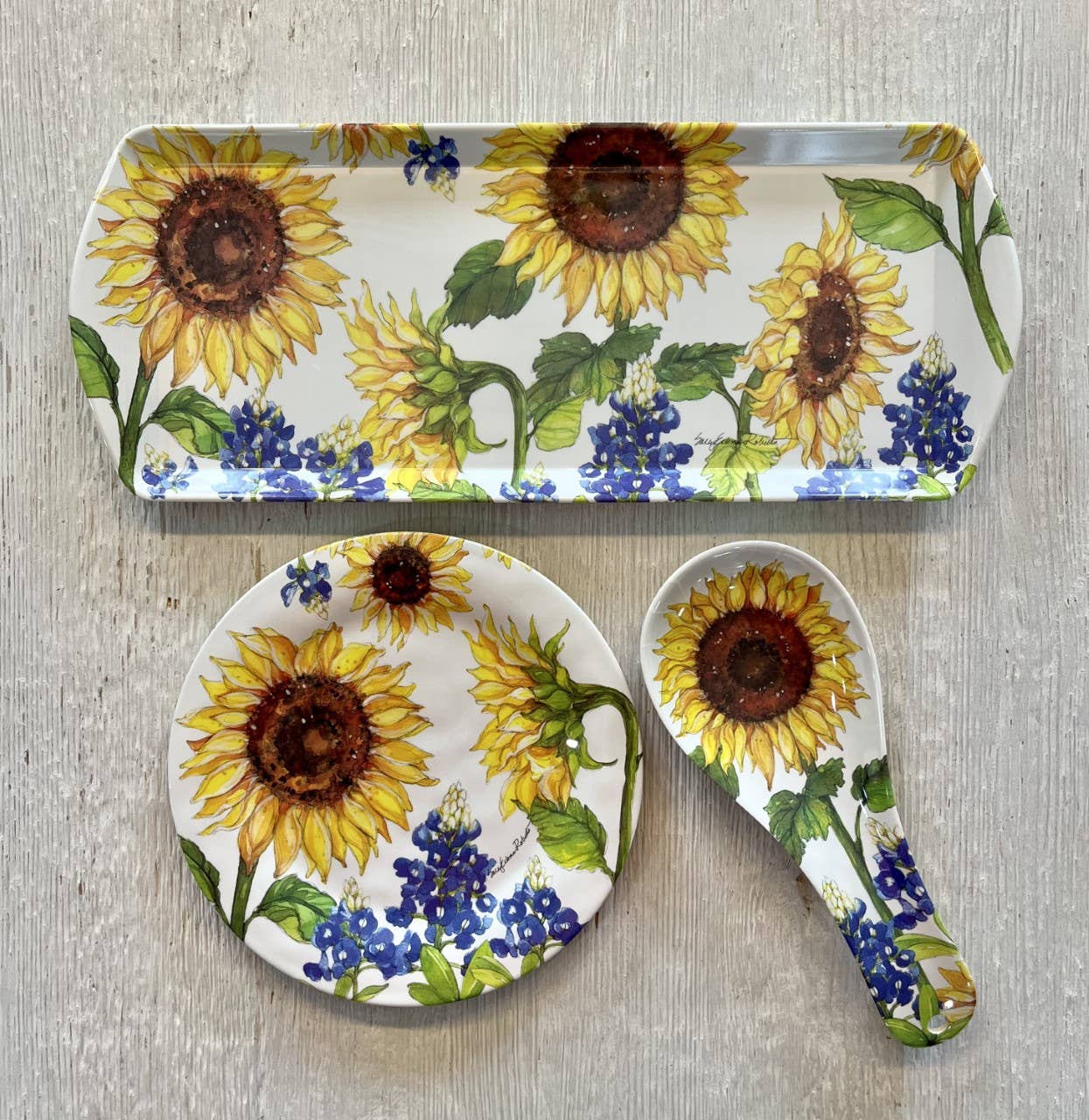 The Sunflower & Bluebonnets Floral Flowers Bamboo Spoon Rest adds a charming floral touch to your kitchen accessories when displayed on a light wood surface.