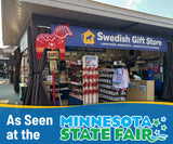 Display booth with Dala horses, souvenirs, a Minnesota State Fair banner, and a red metal Dala horse garden stake among Scandinavian-themed outdoor accents.