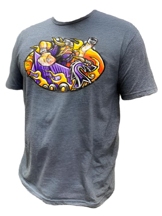 Introducing the "Tee: Turman Merch Co - Norseman," a heather black unisex t-shirt that showcases a cartoon Viking alongside a dragon against an orange backdrop on the chest. It features a classic crew neck design, ensuring both comfort and style.