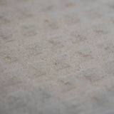 Close-up of a white Swedish dishcloth with a textured surface and repeating raised diamond pattern.