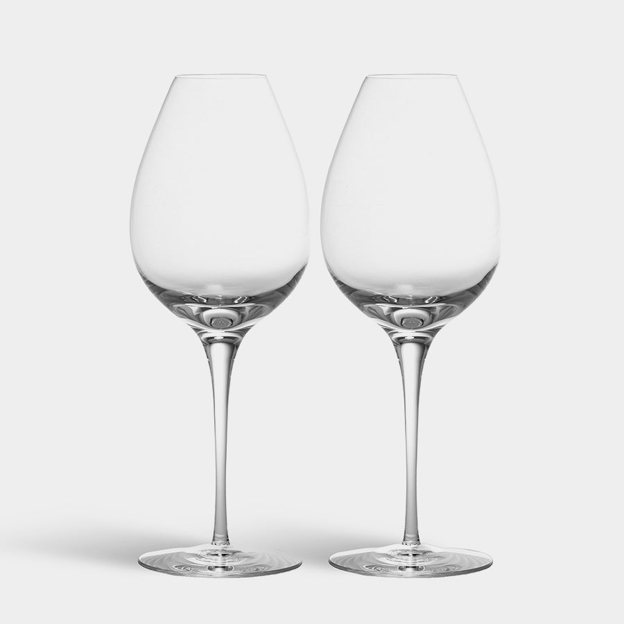 Two Orrefors Difference Primeur Glasses designed by Erika Lagerbielke, empty with long stems and elegant silhouettes, grace the scene against a plain white background.