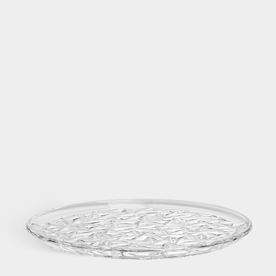 A clear Orrefors: Carat Dinner Plate, designed by Lena Bergstrom, features a textured geometric pattern on its surface and is shown against a plain white background.