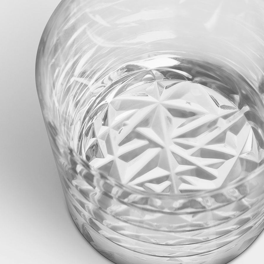 A close-up shows an empty Orrefors Carat Double Old Fashioned glass, featuring a textured geometric pattern at the base, similar to the style in the 2-pack set.