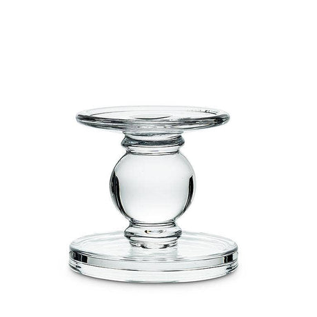 The Candle Holder: Small Reversible Candleholder-2.5"H features a clear glass pedestal with a round top and base, joined by a spherical center—an elegant piece for displaying pillar candles on any tabletop.