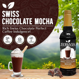 Bottle of Syruvia Swiss Chocolate Mocha Syrup with Pure Cane Sugar, paired with a chocolate mocha drink topped with whipped cream and chocolate pieces—made from authentic Swiss chocolate for a rich treat in an outdoor setting.