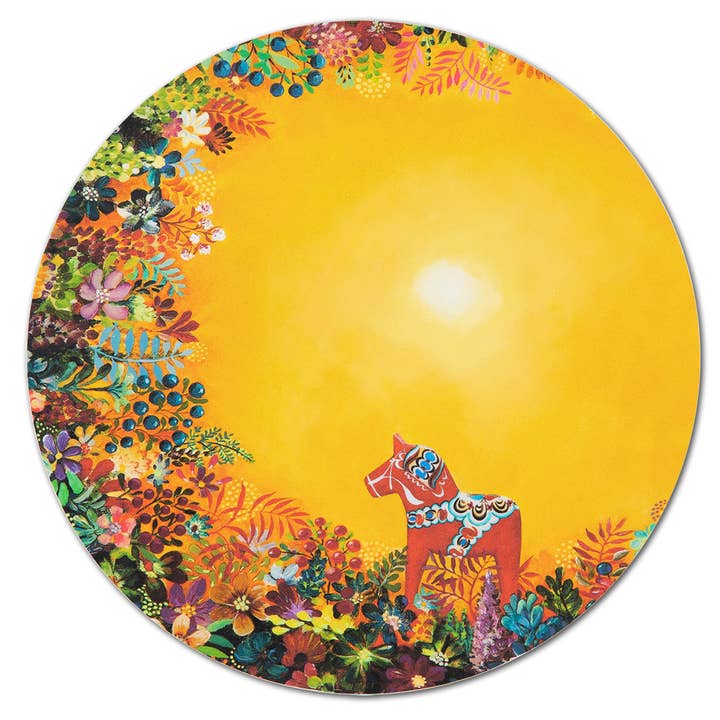 The Light of Grytnäs 8 trivet by Swedish artist Nadja Wedin is a circular piece showcasing a red horse with ornate patterns amidst colorful flowers and foliage on a bright yellow background with a central glowing sun, combining beauty and heat-resistant functionality.