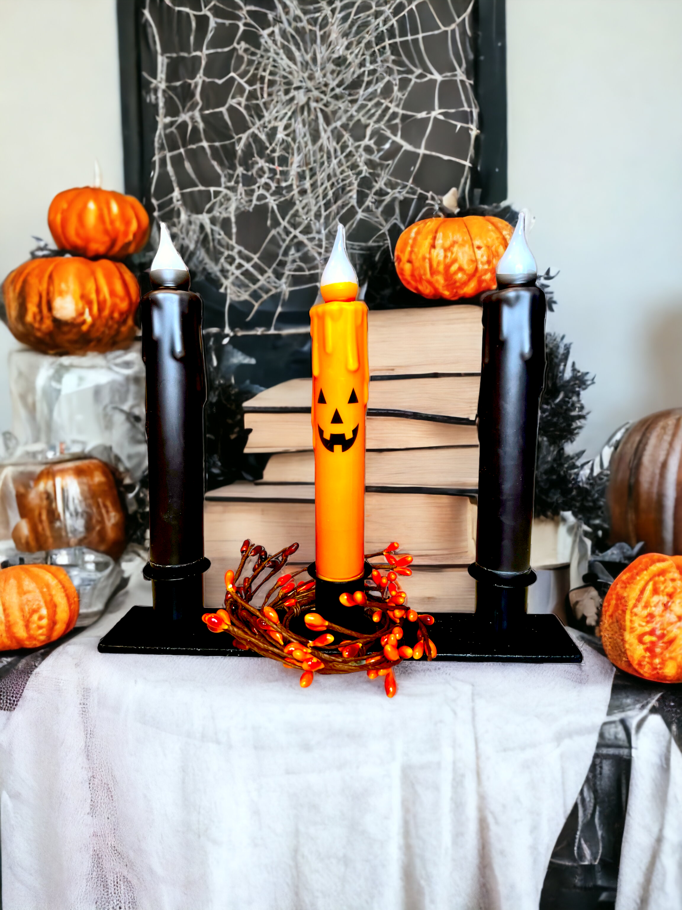 Set the scene for a spooktacular atmosphere with our Halloween-themed display featuring the Jack-O-Lantern Halloween Battery Operated Timer Taper Candle in vibrant orange. Complemented by black candles and surrounded by pumpkins and spider webs, it's perfect for an eerie glow.