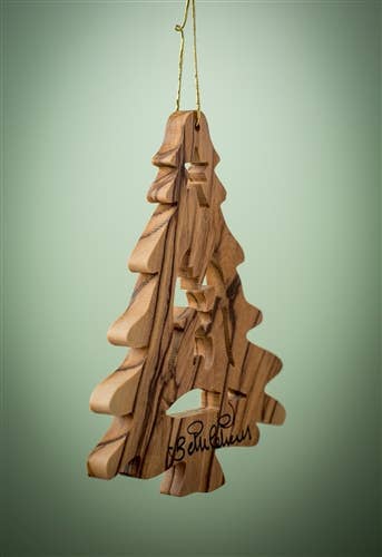 This Ornament: Christmas Tree with Nativity - 3.5" is a delightful wooden creation, shaped like a Christmas tree adorned with intricately carved stars. Made from olive wood, it exudes natural charm and is signed at the bottom.