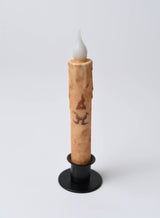 The Candle: Christmas Gnome LED Timer Taper Candle: Cinnamon Dusted features a faux flame, cinnamon-dusted beige finish, gnome illustration, and battery-powered timer—perfect festive decor for the season.