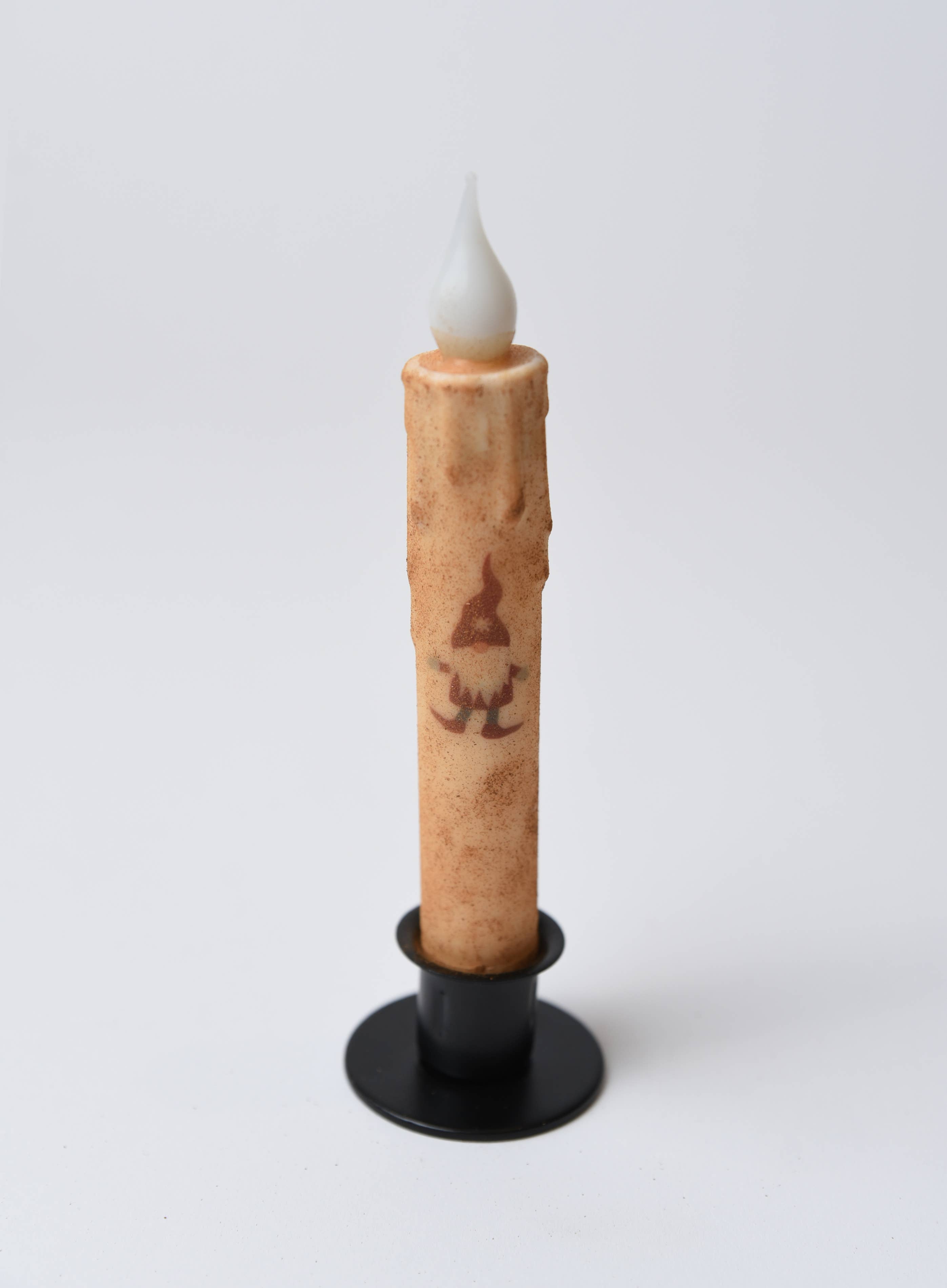 The Candle: Christmas Gnome LED Timer Taper Candle: Cinnamon Dusted features a faux flame, cinnamon-dusted beige finish, gnome illustration, and battery-powered timer—perfect festive decor for the season.