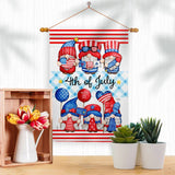 The July 4th Gnome Americana Fourth of Decor Flag features cartoon gnomes in red, white, and blue with festive decorations and text, perfect for displaying above a shelf with flowers and potted plants.