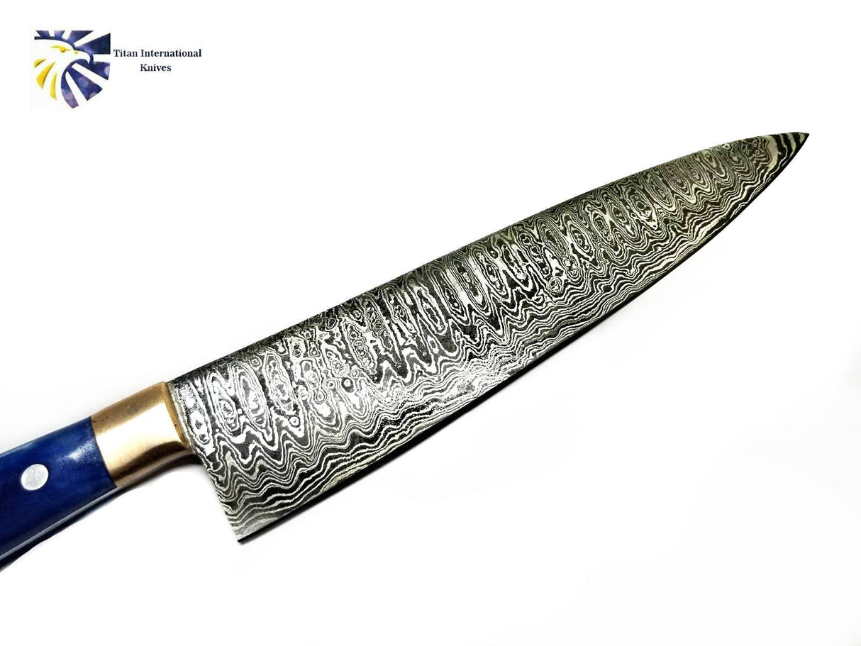 The Knife: Damascus Chef Knife features a patterned Damascus steel blade, blue handle, and brass bolster, shown on a white background with the Titan International Knives logo in the top left corner.