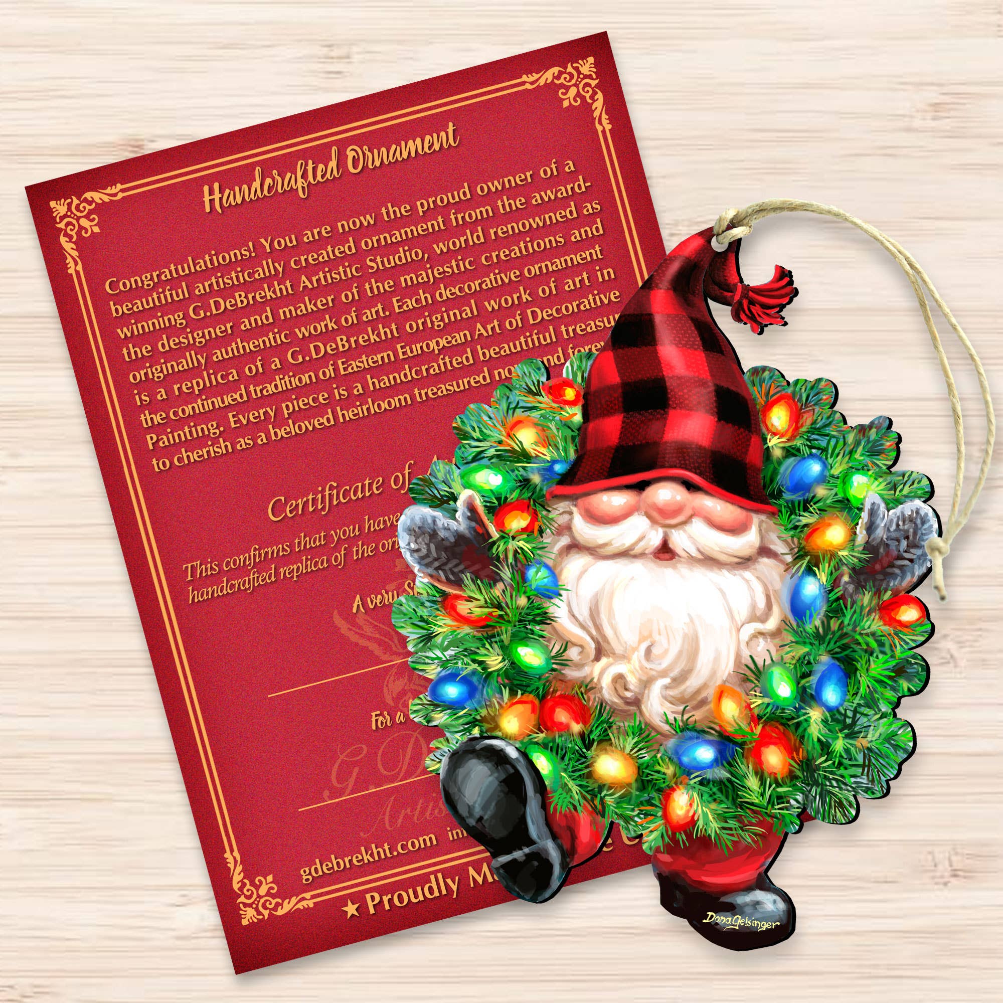 Introducing the Bright Light Gnome Ornament by D. Gelsinger—a handcrafted home decor piece showcasing a gnome with a red and black plaid hat, beautifully framed by a vibrant wreath. Accompanying the ornament is its authenticity certificate.