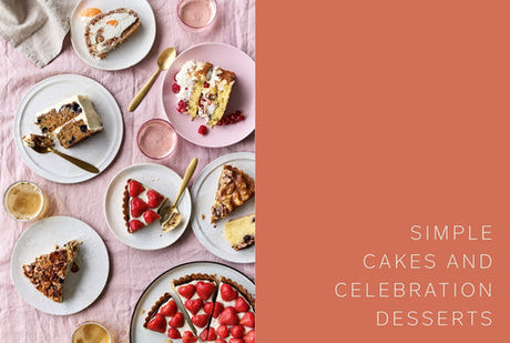 Plates with slices of cake and desserts are set with gold cutlery on a pink cloth. The right side displays “SIMPLE CAKES AND CELEBRATION DESSERTS.” Product: Book: Scandinavian from Scratch by Penguin Random House.