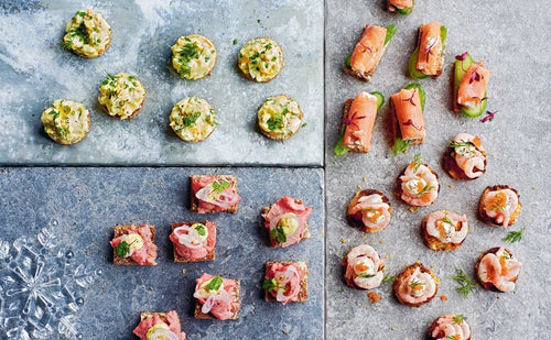 Enjoy an array of bite-sized canapés inspired by Brontë Aurells Smorrebrod Scandinavian Open Sandwiches book, featuring salmon, roast beef, and creamy toppings arranged like classic Nordic open sandwiches.