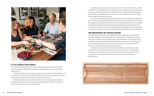 A group of people sits around a table, which is elegantly decorated with food boards, smiling and engaging in conversation. The opposite page highlights information about family meals and showcases the book "Big Boards for Families.