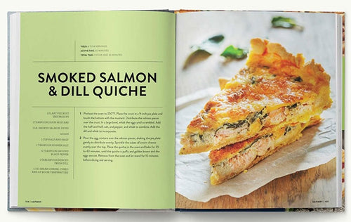 An open "Beautiful Brunches" cookbook showcases a scrumptious smoked salmon and dill quiche recipe on the left, accompanied by an enticing image of two slices on the right—ideal for delighting every guest.