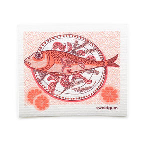 The Dish Cloth: Fish Dinner on a Plate features a fish illustration on a patterned plate with citrus slices, in red and pink hues, plus "sweetgum" printed in the corner—a decorative Swedish-inspired napkin.