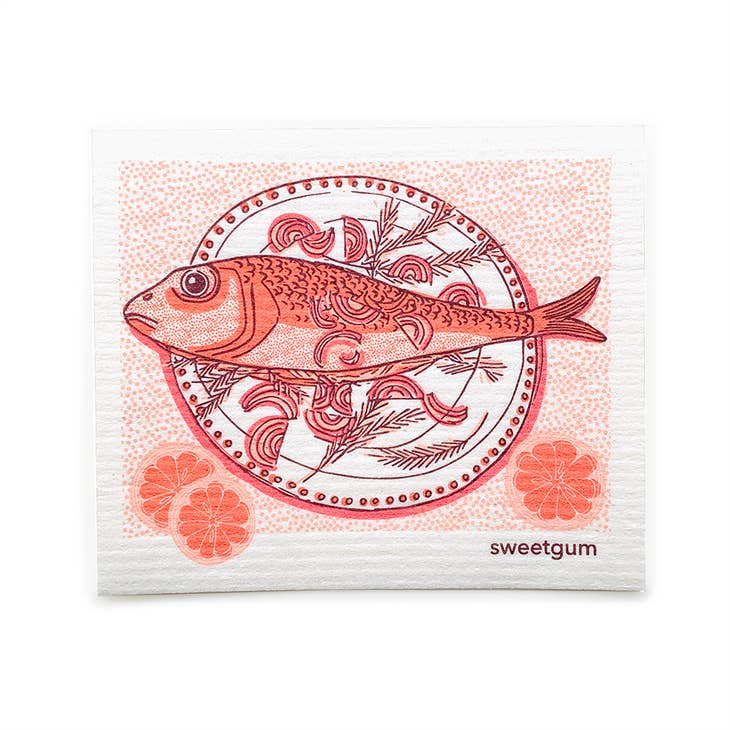 A decorative plate with a fish illustration and floral designs is accompanied by three orange slices, all set against a white background. In the corner, the branding for Sweetgum, renowned for their super absorbent and eco-friendly towels, is prominently displayed.