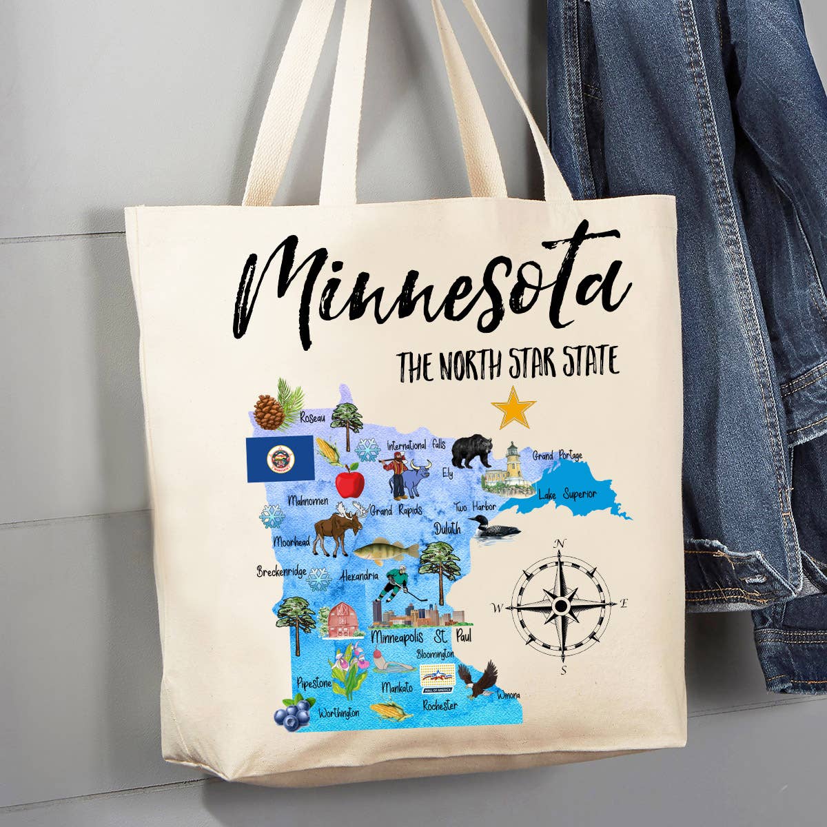 The Minnesota State Map Souvenir 12 oz Canvas Tote Bag is a cotton canvas tote that showcases an illustrated map of Minnesota decorated with symbols, animals, and landmarks, proudly labeled as The North Star State. Adorned with a compass rose, this eco-friendly, reusable shopping bag is perfect for your adventures.