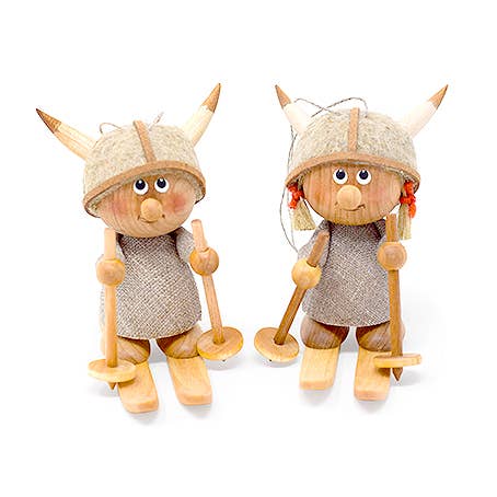 The handcrafted Figurine: Viking Boy Skier set includes two figurines dressed in gray fabric with helmets, each holding wooden ski poles, adding charm to their adventurous Scandinavian decor style.