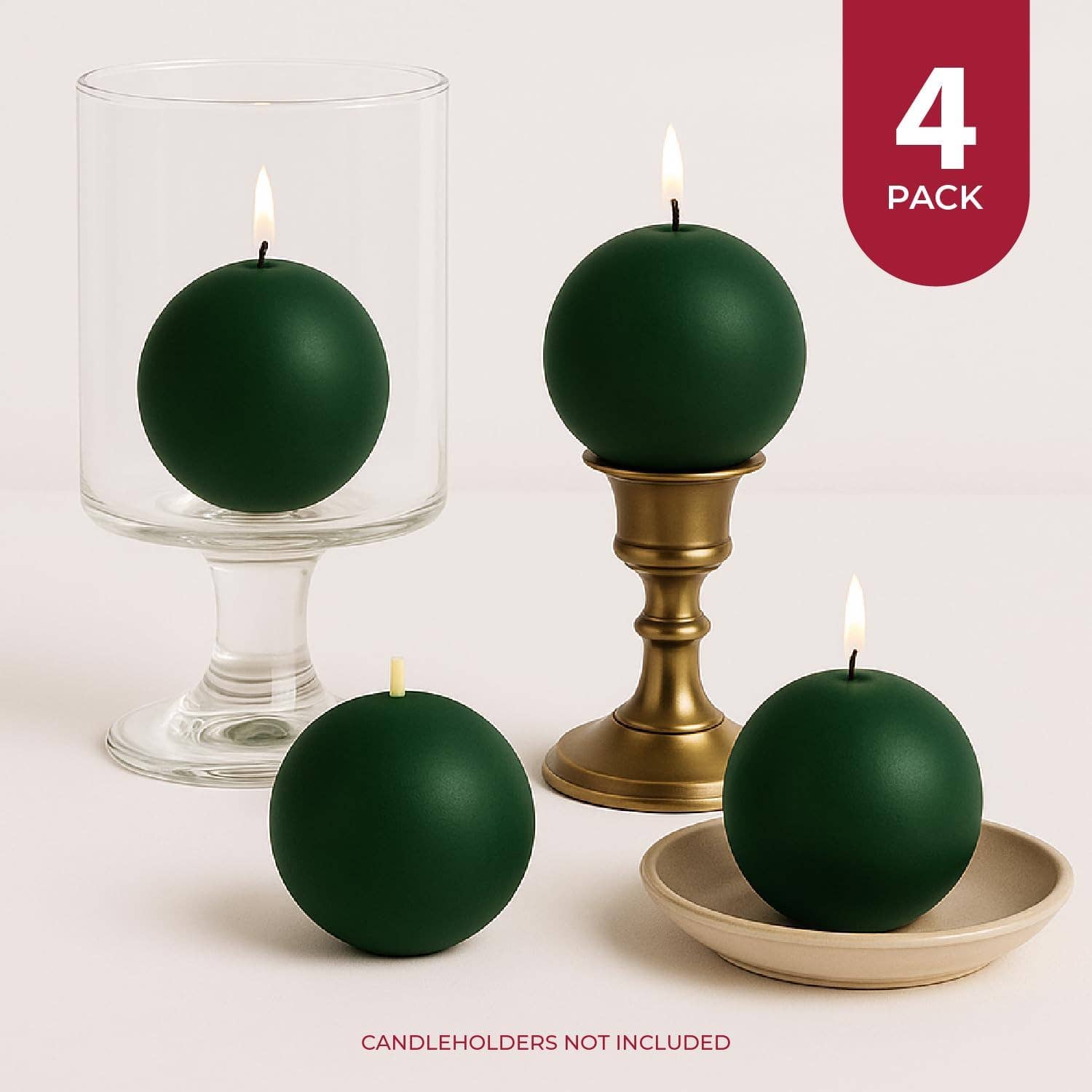 Set of four unscented Pine Green Ball Candles, 2.5" diameter, each burns 8 hours. Two lit on candleholders, two unlit (one on a plate). Candleholders not included.