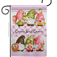 Brighten your decor with the Flag: Gnome Sweet Gnome Garden Flag, featuring four cute gnomes in pink and green holding strawberries and flowers on a pink plaid background with “Gnome Sweet Gnome” text.
