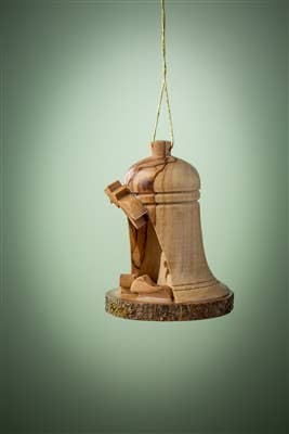 Olive wood ornament shaped as a nativity scene with Mary, Joseph, and baby Jesus, suspended by a gold string on a soft green background.