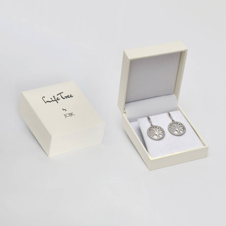 A white JOIK jewelry box rests next to an open box displaying the Earrings: Tree of Life in Sterling Silver with Beautiful Luster on white padding.