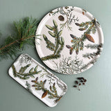 The Tray: Pine Trees - Wood Serving Tray (6x12 inches) for Koustrup Co, made in Sweden, features pine branch and cone designs on green; pictured with a pine twig and small pine cones.