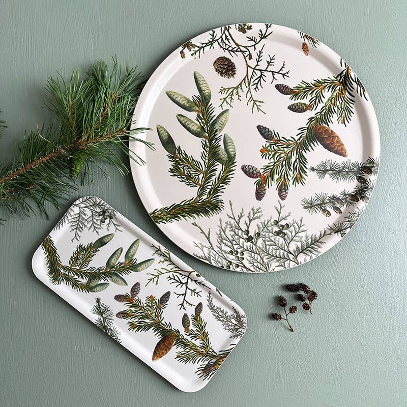 The Tray: Pine Trees - Wood Serving Tray (6x12 inches) for Koustrup Co, made in Sweden, features pine branch and cone designs on green; pictured with a pine twig and small pine cones.