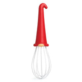 Introducing the OTOTO Whisk: Gnome Wire Whisk—this delightful kitchen helper boasts a red handle shaped like a gnome’s hat, a beige collar, and sturdy white wire loops for mixing. Standing upright on a white background, it adds whimsical flair to any kitchen and makes for a giftable baking tool. When batter needs blending and cream needs whipping, this cheerful gnome spins through the bowl with a hop and a skip!.