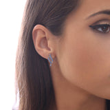 Close-up of a woman’s ear wearing April Crystal Spiral Dangle Earrings with Swarovski® Crystals, set against a neutral background.